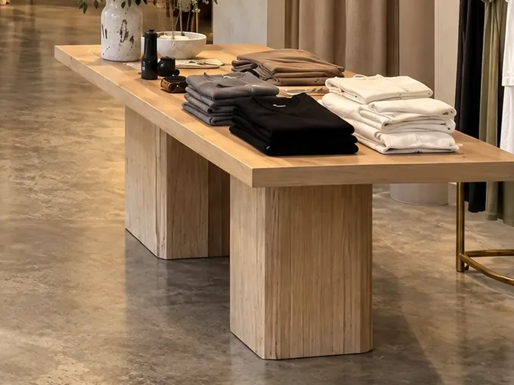 Folded knitwear stacked on a pale timber table